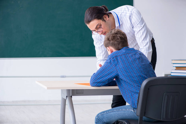 Young male teacher and boy in the classroom - Photo, Image