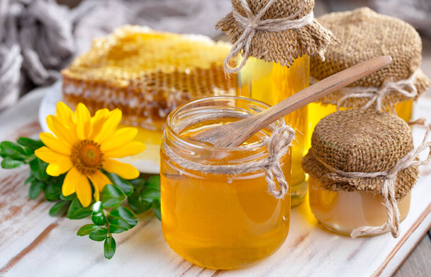 Bee honey in a jar with a flower, on the old background. - Fotoğraf, Görsel