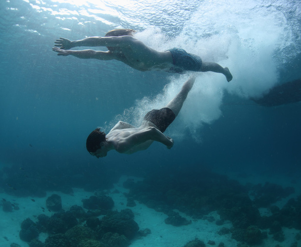 Two men gliding in a sea after jump - Foto, Imagem