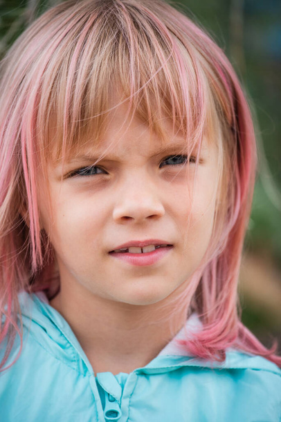 Schattig kinderportret. Outdoor portret van schattig klein meisje in de zomer dag. Portret van een klein meisje met roze haar. Kind van 6-7 jaar - Foto, afbeelding