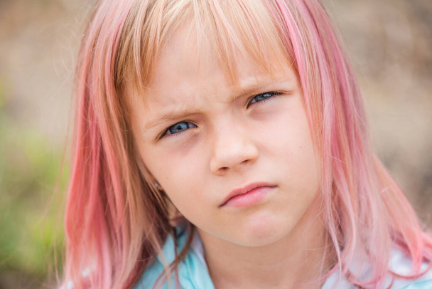милый портрет девочки. Открытый портрет симпатичной маленькой девочки в летний день. Портрет маленькой девочки с розовыми волосами. Ребенок 6-7 лет - Фото, изображение