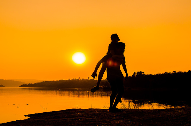 casal silhueta na margem do lago
 - Foto, Imagem