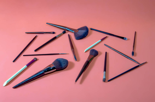 diferente tipo y tamaño de cepillos de maquillaje profesional sobre fondo naranja - Foto, Imagen