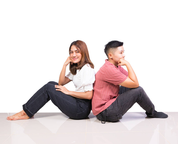 Dos chicas jóvenes sonrientes y amigos tomboy felicidad sentados espalda con espalda en el suelo con fondo blanco - Foto, imagen