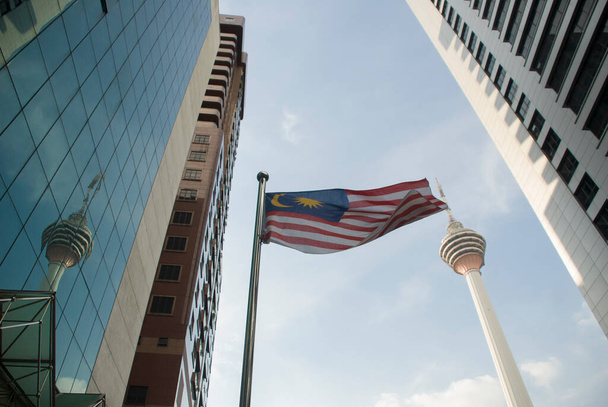 Kuala Lumpur, Malaysia - October 28, 2010: Malaysian flag among financial buildings  and Menara Tower, a city landmark on background - Foto, immagini