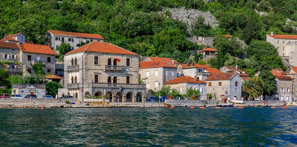 Landschappelijk uitzicht op een ansichtkaart perfecte historische stad Perast Montenegro oude Venetiaanse stad in Kotor Bay op een zonnige zomerdag, bergen op de achtergrond - Foto, afbeelding
