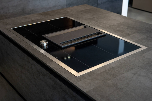 Modern luxury kitchen. Modern black induction cooker on marble countertop. Hight quality photo - Fotoğraf, Görsel
