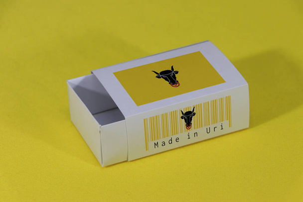 Uri flag on white box with barcode and the canton color flag of Switzerland on black background, paper packaging for put match or products. The concept of export trading from Uri. - Photo, Image