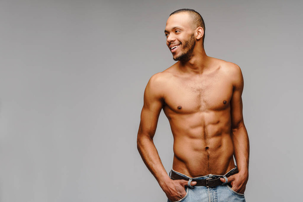 Sexy joven musculoso africano americano hombre sin camisa sobre fondo gris claro - Foto, imagen