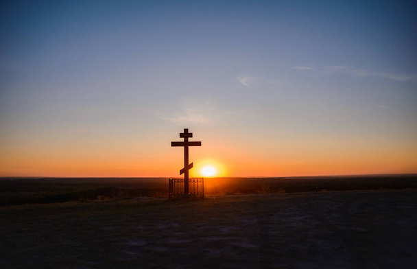 Sylwetka krzyża na tle zachodu słońca w górach - Zdjęcie, obraz