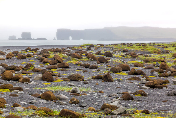 Uitzicht op het strand van Reynisfjara met indrukwekkende basaltzuilen in Zuid-IJsland in de zomer - Foto, afbeelding