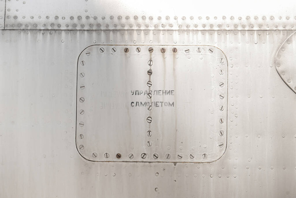 Antigua superficie metálica plateada del fuselaje de la aeronave con remaches - Foto, imagen