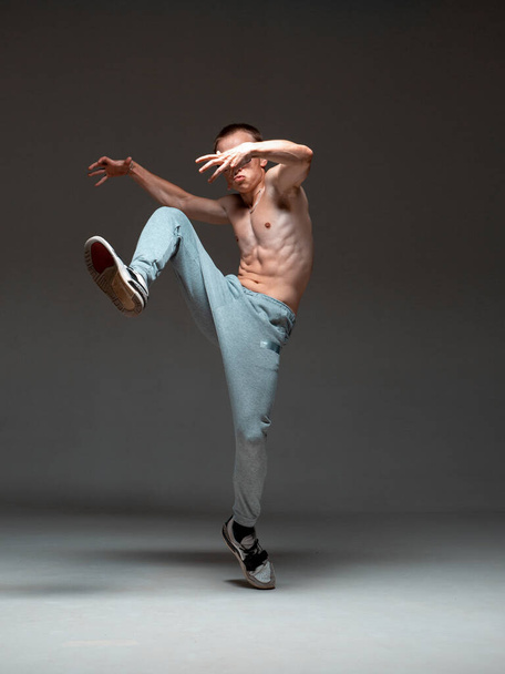 Cool guy breakdancer dancing hip-hop without shirt in studio. Dance school poster. Break dance lessons - Photo, image