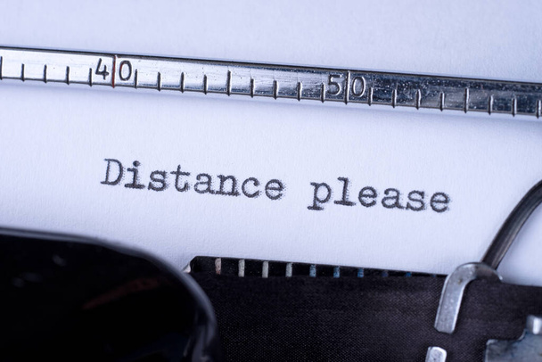 Distance please on white sheet in vintage typewriter - Photo, Image