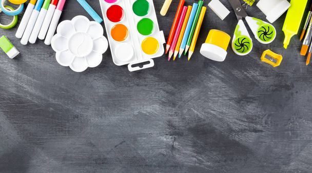 Various school office and painting supplies on black background. Back to school concept. Top view. Copy space - Фото, зображення