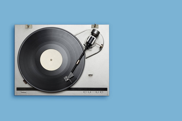 Reproductor de vinilo con larga reproducción o disco LP sobre fondo azul. Vista superior, espacio de copia. - Foto, Imagen