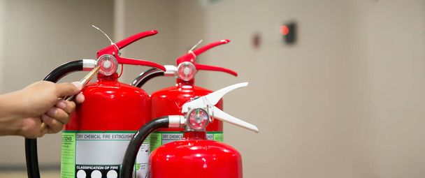Hasiči kontrolují červenou nádrž hasicích přístrojů v koncepci protipožární ochrany a bezpečnostní záchrany požárních služeb a výcviku. - Fotografie, Obrázek