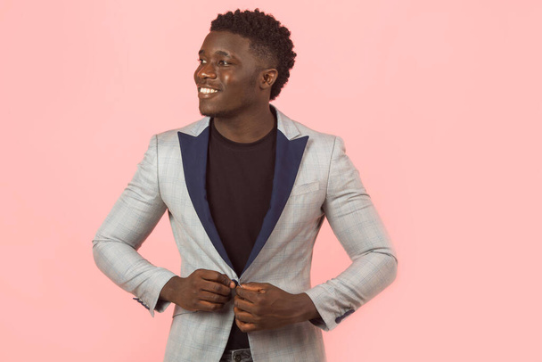 handsome young african male in jacket, on pink background - Foto, Imagen