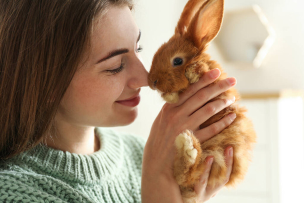 Young woman with adorable rabbit indoors, closeup. Lovely pet - Fotoğraf, Görsel