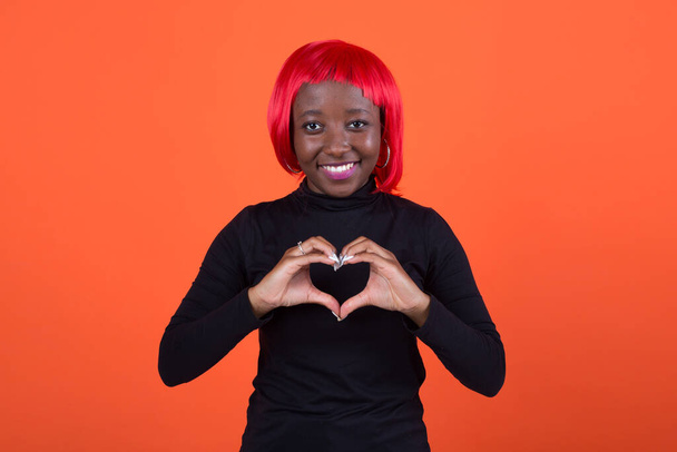 beautiful young african female with red hair on a red background - Фото, изображение