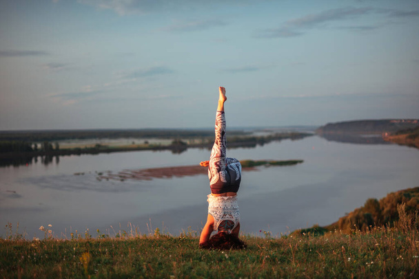 Yoga beoefening en meditatie in de natuur bij zonsopgang. vrouw oefenen in de buurt van grote rivier Kama. - Foto, afbeelding