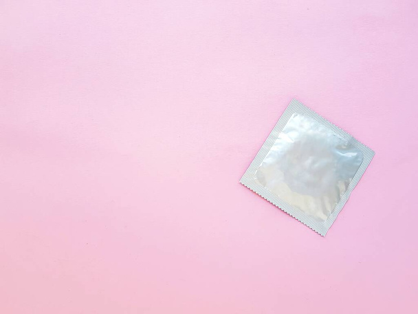 Condom on a pink background. The concept of safe sex and protection from sexually transmitted infections. - Foto, Imagen