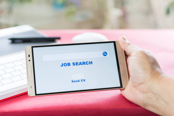 A hand holding a smartphone with 'Job search' written on the screen - Fotoğraf, Görsel