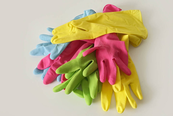 Un primer plano de guantes de goma de colores en una superficie blanca - Foto, Imagen