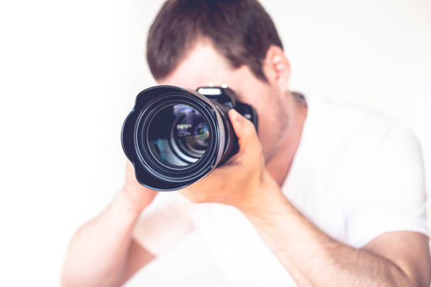 A closeup of a young man holding a camera - Foto, afbeelding