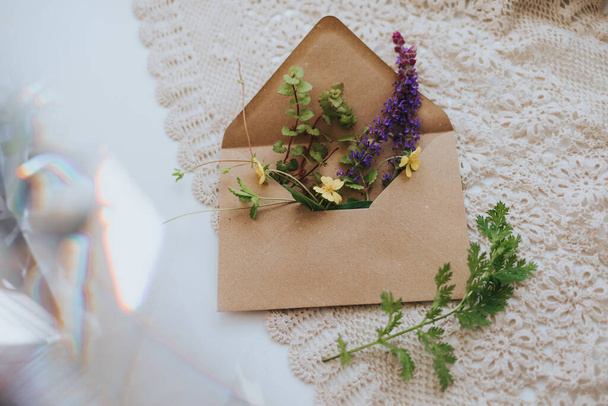 A selective focus shot of lavender and small yellow flowers in an envelope on white fabric - Fotoğraf, Görsel