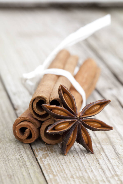 A vertical closeup shot of cinnamon sticks on a wooden surface - Zdjęcie, obraz