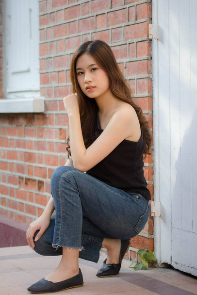 Portrait of thai china adult beautiful girl black shirt blue jeans relax and smile - Foto, Bild