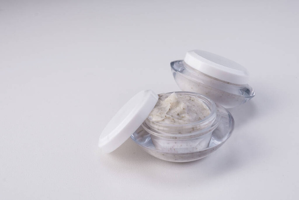 A closeup of face cream in small jars isolated on a white background - Fotó, kép