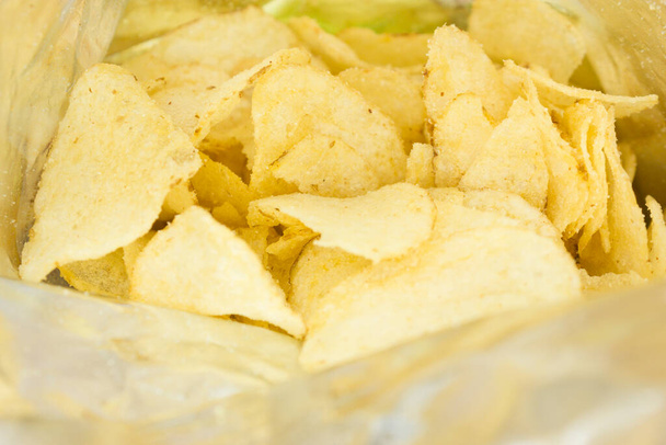 крупным планом загляните внутрь пакета картофельных чипсов или пачки чипсов, сыра и лука - Фото, изображение