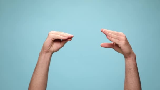twee handen praten met elkaar, klampen zich vast en geven een duim naar beneden tegen een blauwe achtergrond - Video