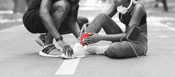 Lesiones deportivas. Chica negra masajeando el tobillo torcido, sufriendo de trauma durante el trote - Foto, Imagen