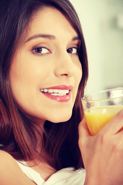 Woman in bed drinking orange juice - Foto, Bild