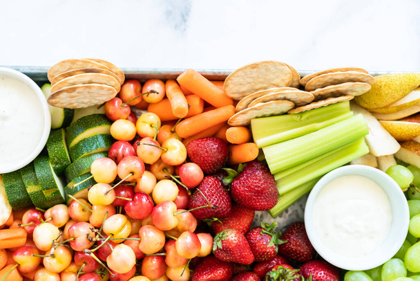 Tavola snack con frutta fresca, verdura, cracker e salse. - Foto, immagini