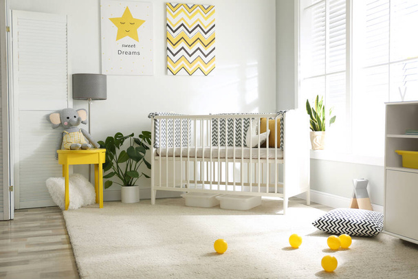 Cute baby room interior with crib and big window - Foto, afbeelding