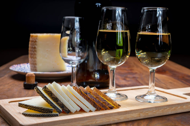 Trockener spanischer Fino-Sherry-Wein aus Andalusien und Stücke verschiedener Schafshartkäse aus Manchego, hergestellt in La Mancha, Spanien. Paarung von Wein und Käse - Foto, Bild