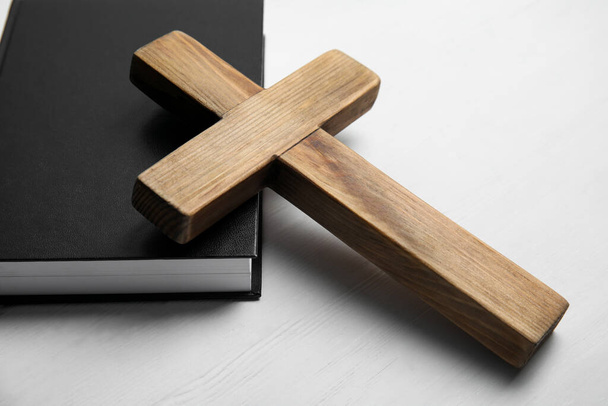 Christian cross and Bible on white wooden background, closeup. Religion concept - Foto, afbeelding
