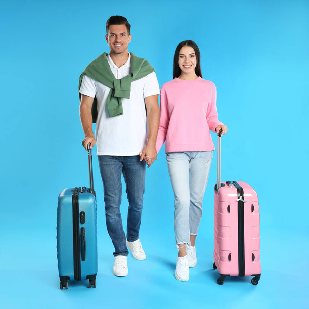 Счастливая пара с чемоданами для летней поездки на голубом фоне. Отдых - Фото, изображение