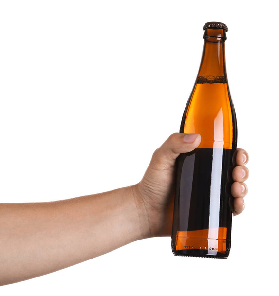 Man holding brown bottle with beer on white background, closeup - 写真・画像