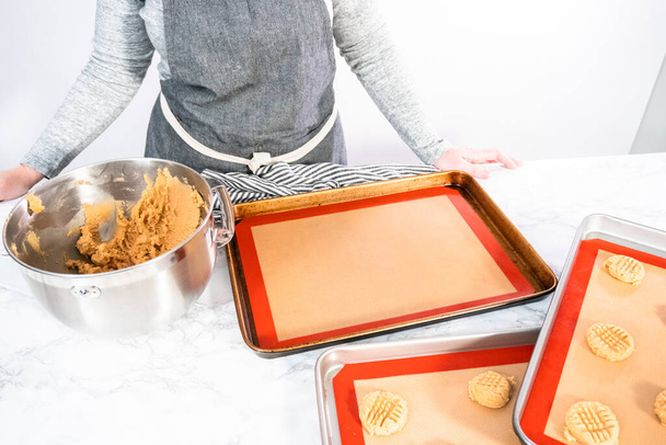 Placer une pâte à biscuits au beurre d'arachide sur des tapis en silicone pour la cuisson. - Photo, image