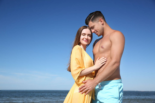 Beautiful woman and her boyfriend on beach. Happy couple - Zdjęcie, obraz