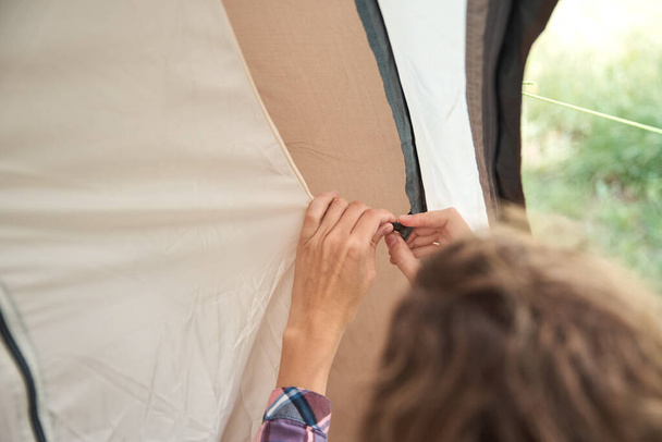 Woman setting up camping tent at forest, close up - Foto, imagen