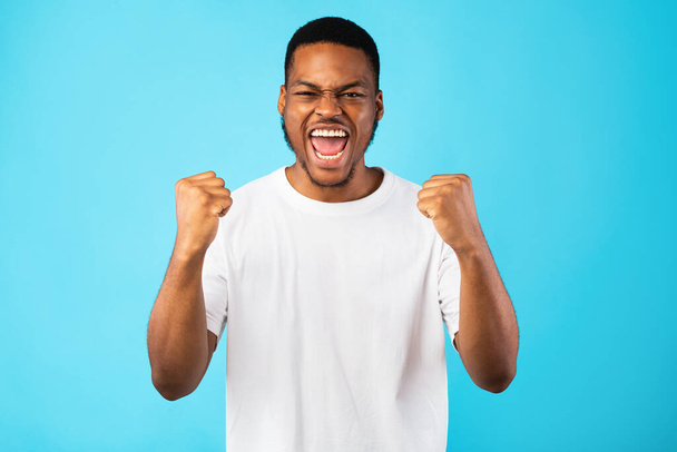 Emotional Black Guy Shouting Yes Shaking Fists On Blue Background - Valokuva, kuva