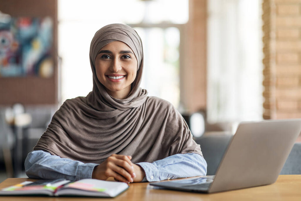 Smiling arab girl looking for job online, sitting at cafe - Foto, Imagem