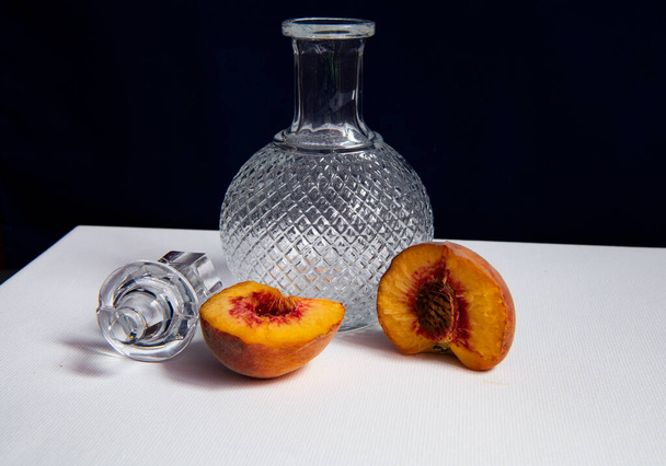 still life with a beautiful glass decanter and fruits on a dark background - Photo, Image