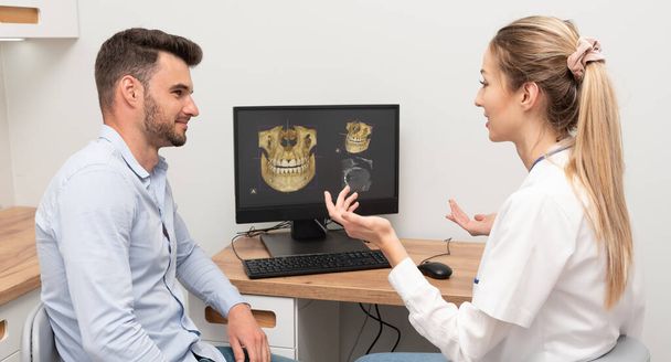 Computer diagnostics dental tomography. Dentist shows the patient an x-ray image at display. Dental care concept. - Valokuva, kuva